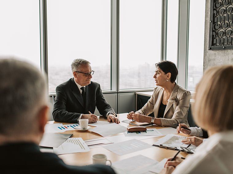Executives around a boardroom table, mid decision
