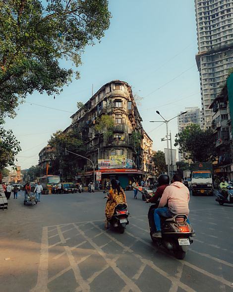 A street in Mumbai, scooters passing a heritage frontage