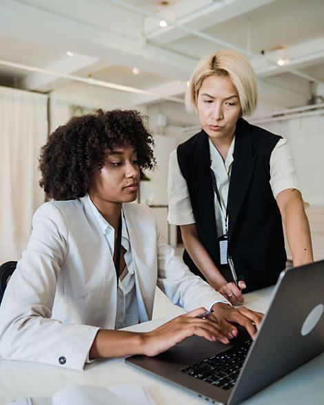 Two colleagues working side by side in a bright office